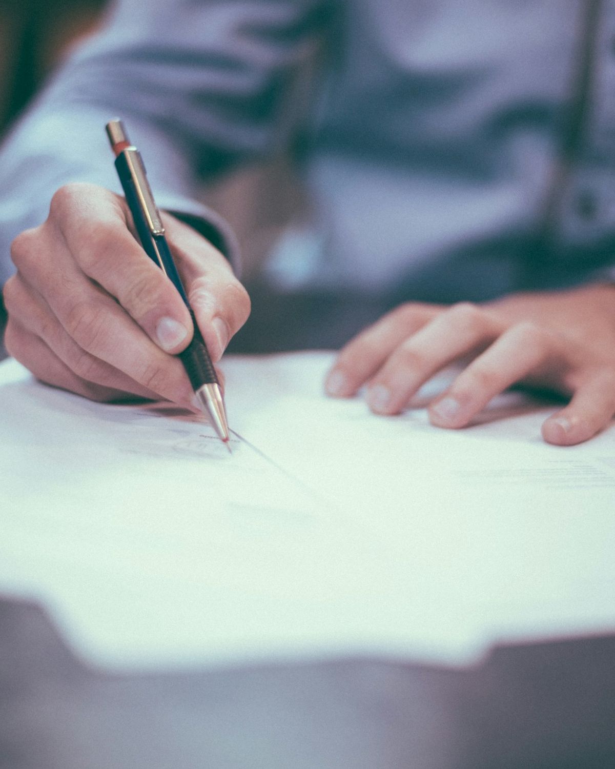 A form being completed and signed with a pen
